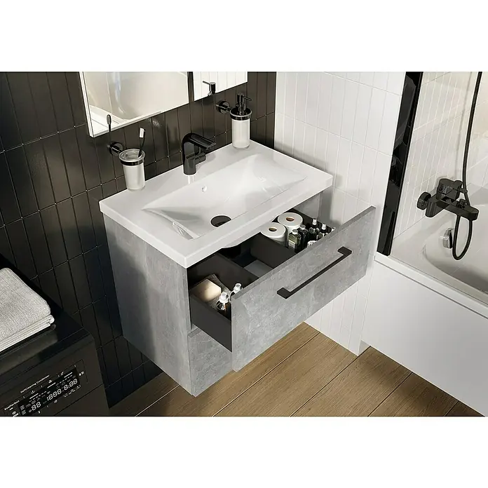 Riva Compact Badmöbel-Set - Gesamtbreite Badmöbel: 61,7 cm, Beton-Optik - Nahaufnahme eines Badezimmers mit einem Waschtischunterschrank mit offenem Auszug, der Badutensilien enthält.