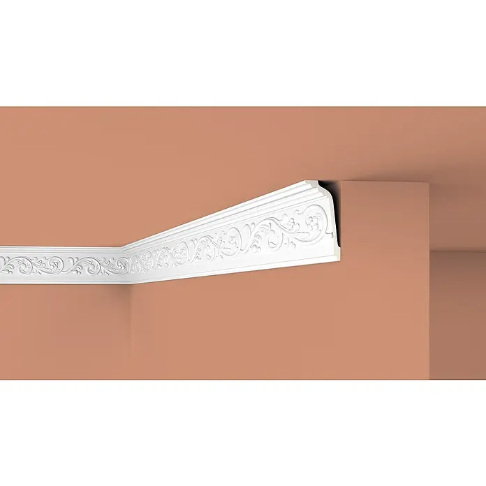 Nmc Decoflair Zierprofil Deckenleiste F18 - 2 m x 69 mm x 148 mm, Hochverdichteter Polyurethanschaum (PU) - Detailaufnahme einer kunstvollen, weißen Deckenleiste mit floralem Muster in einem Raum mit terracottafarbenen Wänden.