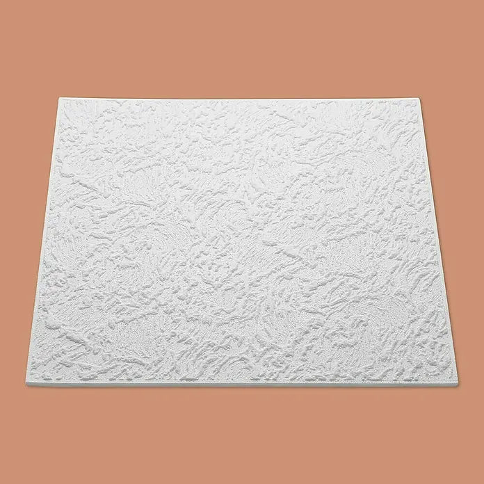 Nmc Decoflair Deckenplatte T105 - 50 x 50 cm, Weiß, Polystyrol - Nahaufnahme einer strukturierten weißen Deckenplatte mit unregelmäßigem Muster auf braunem Untergrund.