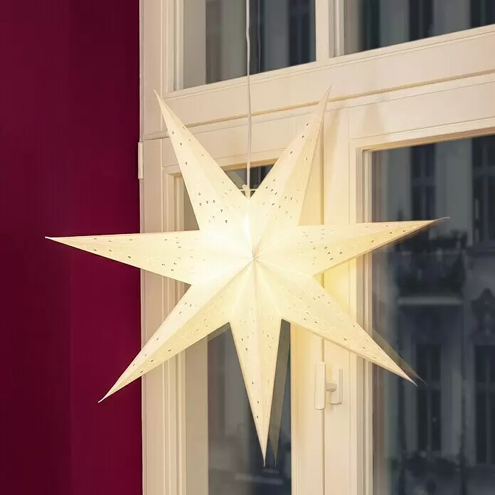 Markslöjd LED-Stern Gisel - 75 cm, Schwarz, IP20, Netzbetrieben - Eine beleuchtete, hellfarbene Papierstern-Laterne mit aufwendigen Mustern, die vor einem Fenster hängt und festlich leuchtet.