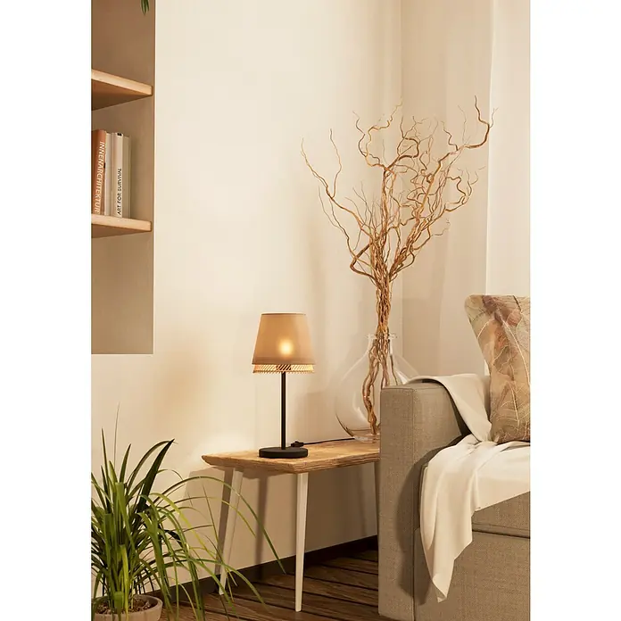 Eglo Tabley Lámpara de sobremesa - 40 W, E27 - Primer plano de una lámpara de mesa con pantalla beige sobre una mesa de madera junto a un sofá, creando un ambiente acogedor.