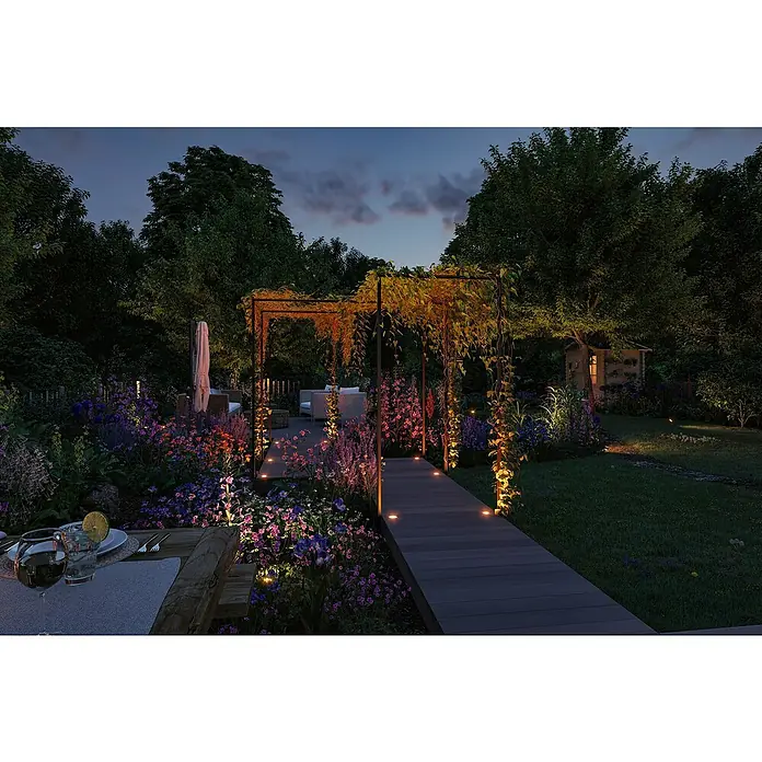 Paulmann Plug & Shine Bodeneinbauleuchte Floor Mini insektenfreundlich - 4,5 cm, Bernstein, IP67, Anthrazit - Ein einladender Garten bei Nacht mit stimmungsvoller Beleuchtung, die Pflanzen und architektonische Details hervorhebt.