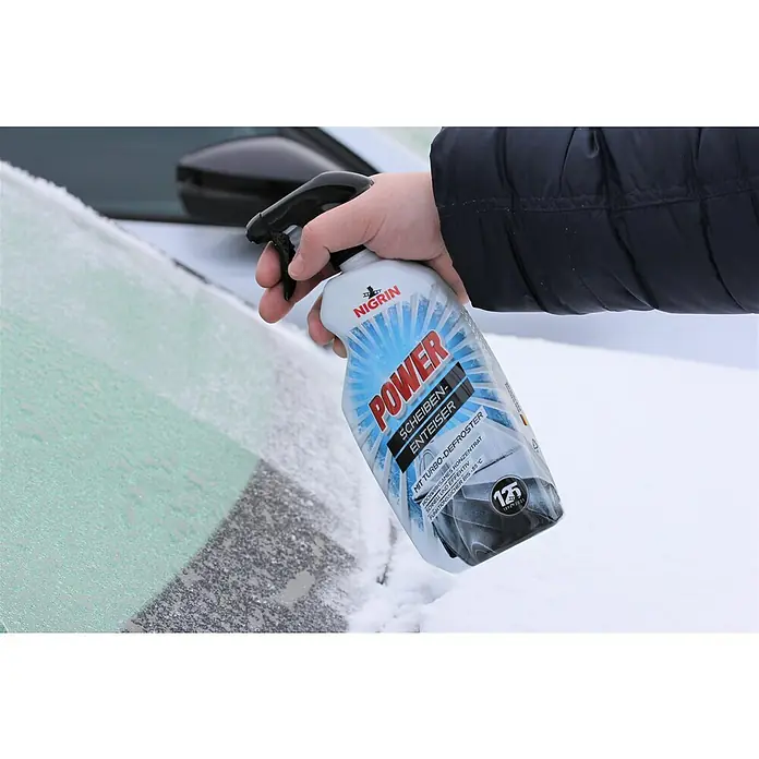 Nigrin Scheibenenteiser Power - 750 ml, Max. Frostbeständigkeit: -55 °C - Eine Hand sprüht Nigrin Power Scheibenenteiser auf eine vereiste Windschutzscheibe.