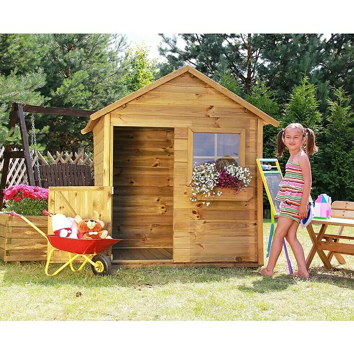 Spielhaus Matthias - L x B x H: 126 x 112 x 157 cm, Holz, Natur - Eine junge Frau steht vor einem Holzspielhaus mit Blumenkasten, einer Tafel und einer Schubkarre mit Spielzeug.