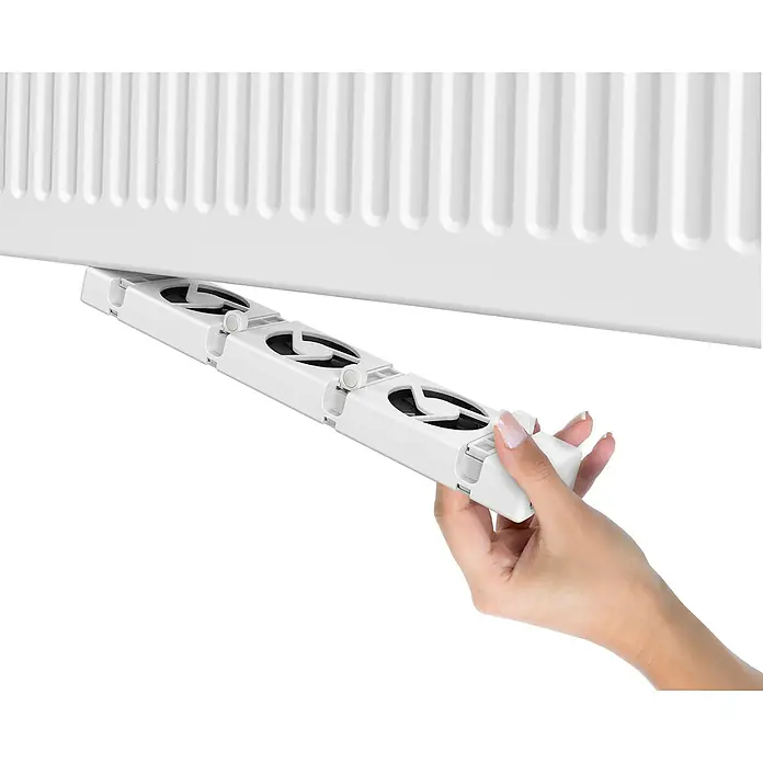 SpeedComfort Heizkörperventilator Duo-SetL x H: 34 x 2,5 cm, Weiß, 2 Stk. - Eine Hand befestigt einen weißen Heizkörperlüfter unter einem Heizkörper, um die Wärmeverteilung zu optimieren.