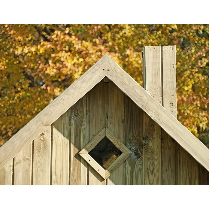 Spielhaus Maya - L x B x H: 263 x 278 x 231 cm, Holz, Natur - Nahaufnahme eines Holzhauses mit Giebeldach, kleinem Fenster und Schornstein vor herbstlichem Hintergrund.
