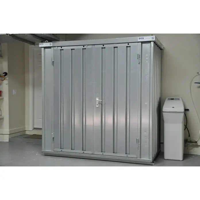 BOS Best of Steel Schnellbaucontainer SC3000+1X2-SZ1 x 2,1 x 2,1 m, Stahl, Doppeltür - Ein silberner BOS Metallschrank mit abschließbaren Türen und einem Griff steht in einem Raum mit einem grauen Boden.