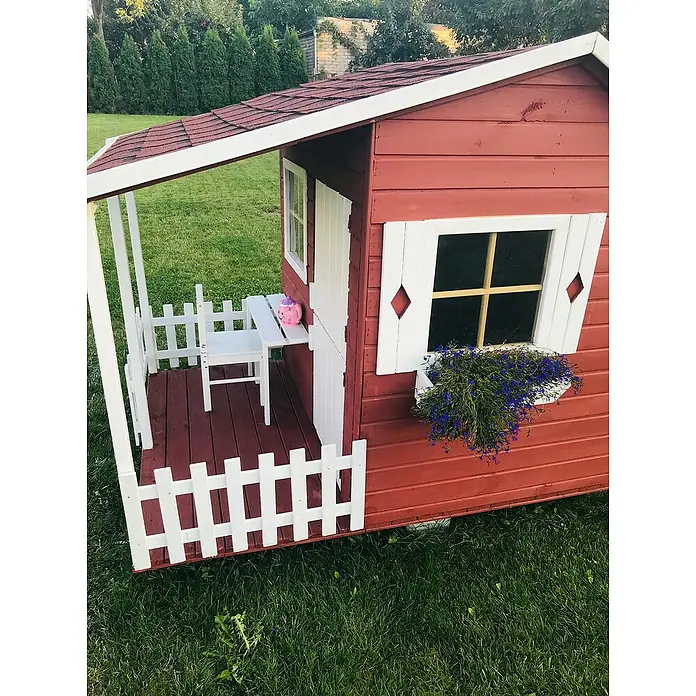Spielhaus Mia - L x B x H: 190,5 x 143 x 159 cm, Holz, Natur - Nahaufnahme eines roten Kinder-Spielhauses mit weißen Akzenten, einer Veranda und einer Fensterbank mit blauen Blumen auf einem grünen Rasen.