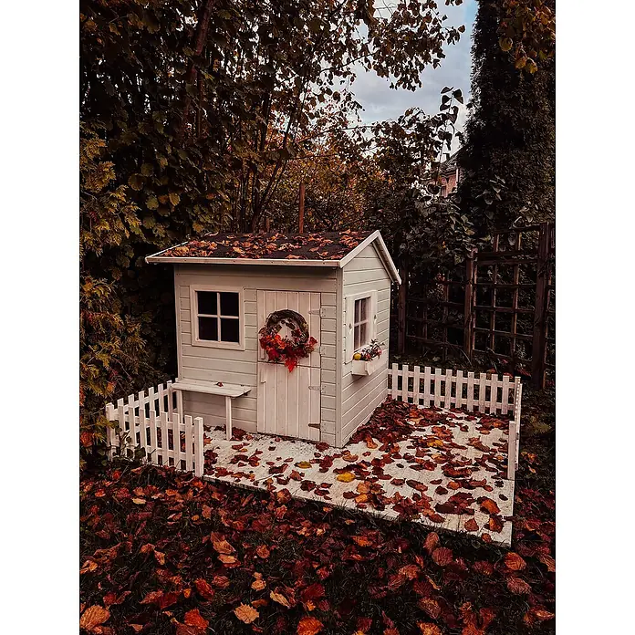 Spielhaus Mia - L x B x H: 190,5 x 143 x 159 cm, Holz, Natur - Das gemütliche Spielhaus mit weißem Lattenzaun und herbstlichen Blättern bietet Kindern einen zauberhaften Rückzugsort im Garten.