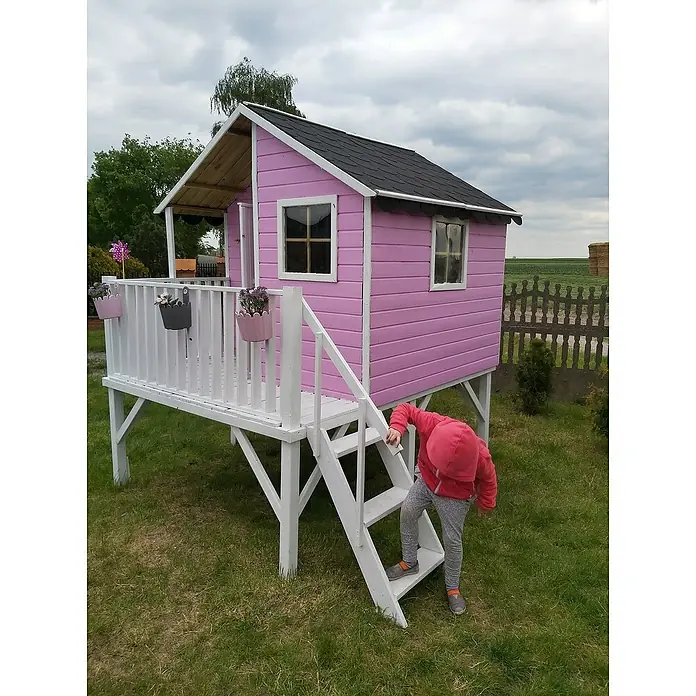 Spielhaus Jeremy - L x B x H: 175 x 226 x 250,5 cm, Holz, Natur - Ein rosafarbenes Spielhaus auf Stelzen mit einem Kind auf der Treppe, ideal für fantasievolles Spielen im Garten.