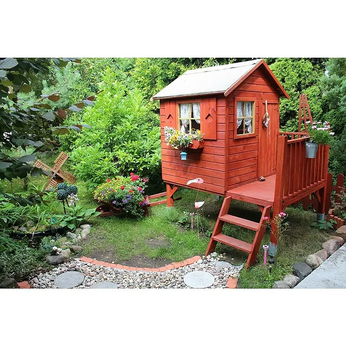 Spielhaus Tobias - L x B x H: 179 x 161 x 221 cm, Holz, Natur - Ein rotes Spielhaus mit einer Leiter und einem kleinen Balkon in einem Garten, umgeben von üppigem Grün und Blumen.
