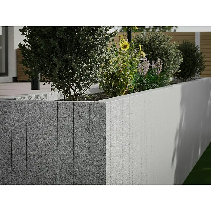 Palisade G 603 - 180 x 12 x 12 cm, Grau - Nahaufnahme eines erhöhten Pflanzgefäßes aus Beton mit vertikalen Paneelen, bepflanzt mit üppigem Grün und gelben Blüten.