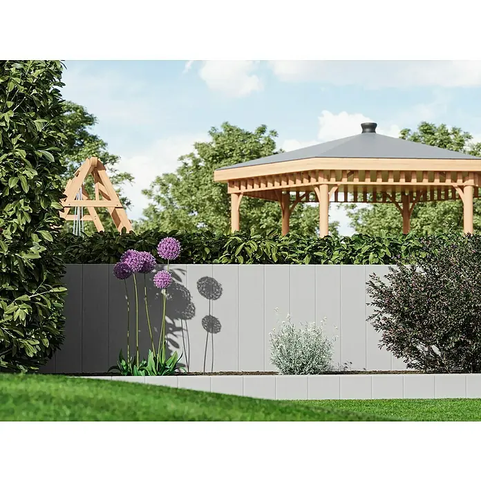 Diephaus Rechteckpalisade - 16,5 x 12 x 100 cm, Grau, Beton - Eine graue Gartenmauer mit lila Allium-Blüten, silbrigem Laub und einem Beet, im Hintergrund ein Holzpavillon und eine Schaukel.