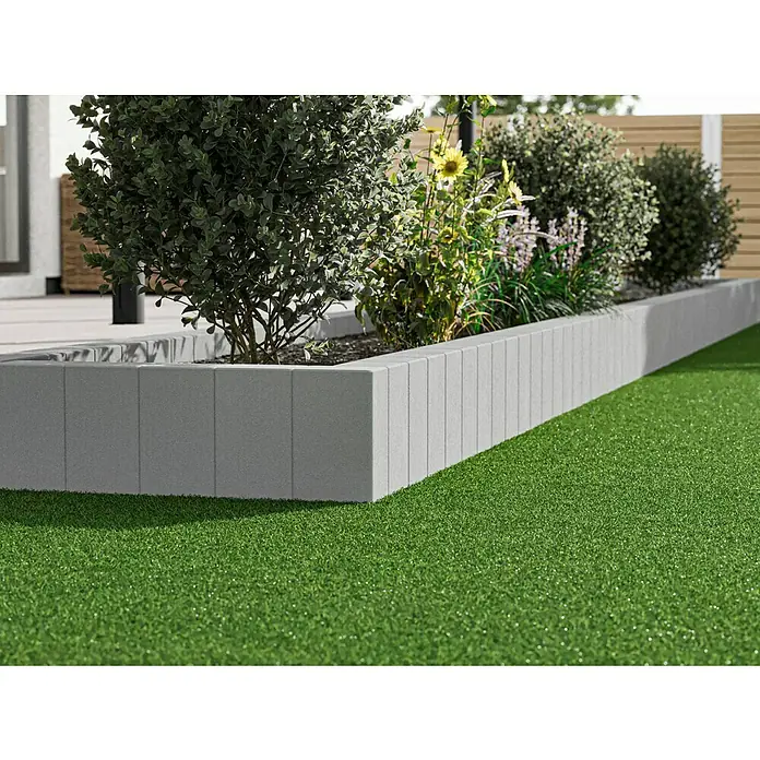 Diephaus Rechteckpalisade - 16,5 x 12 x 40 cm, Grau, Beton - Nahaufnahme eines mit grauen Steinen umrandeten Hochbeets mit üppigen Pflanzen und Blumen auf einem grünen Rasen.