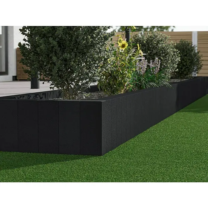 Diephaus Rechteckpalisade - 16,5 x 12 x 60 cm, Anthrazit, Beton - Erhöhter Garten mit einem Pflanzgefäß aus modularen schwarzen Blöcken, bepflanzt mit Büschen und Blumen.