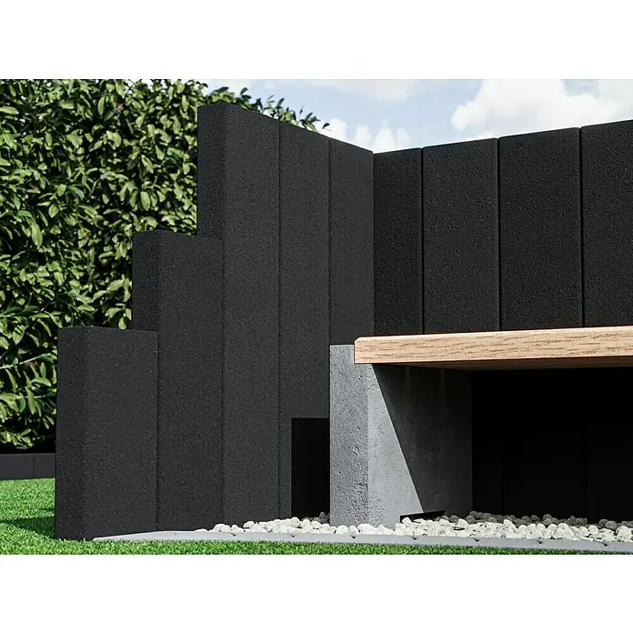 Diephaus Rechteckpalisade Mini - Anthrazit, 8 x 20 x 60 cm, Beton - Detailaufnahme einer modernen Gartengestaltung mit schwarzen Betonblöcken und einer Sitzbank aus hellem Holz.