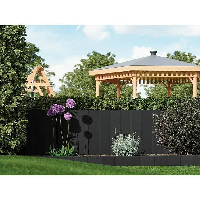 Diephaus Rechteckpalisade - 16,5 x 12 x 100 cm, Anthrazit, Beton - Gartenszene mit einer schwarzen Gartenmauer, lila Zierlauch, grünen Pflanzen und einem hölzernen Pavillon im Hintergrund.