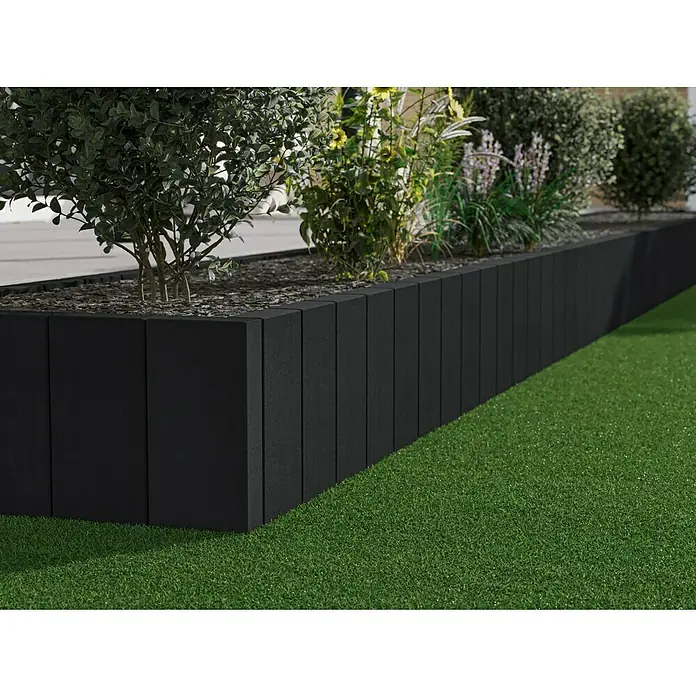 Diephaus Rechteckpalisade Mini - Anthrazit, 8 x 20 x 60 cm, Beton - Schwarze Rasenkantensteine umranden ein Blumenbeet mit verschiedenen Pflanzen. Der Rasen ist grün und gepflegt.