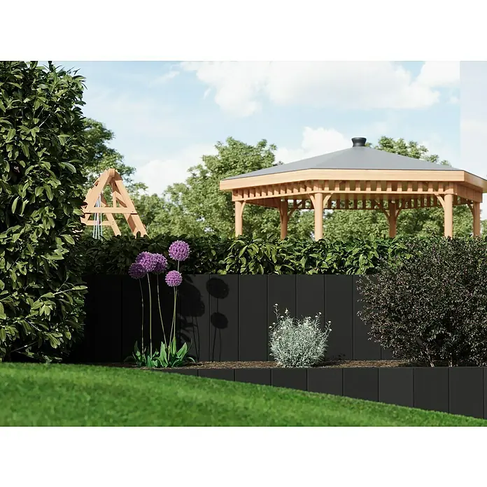 Diephaus Rechteckpalisade Mini - Anthrazit, 8 x 20 x 90 cm, Beton - Eine Gartenansicht mit einem erhöhten schwarzen Blumenbeet und lila Allium-Blüten, im Hintergrund ein hölzerner Pavillon.
