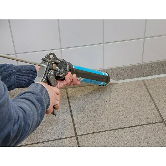 Wisent Kartuschenpresse Profi Qualität - Geeignet für: Verbundmörtel - Eine Kartuschenpistole wird verwendet, um eine weiße Dichtungsmasse zwischen Fliesen aufzutragen, um eine wasserdichte Abdichtung zu gewährleisten.