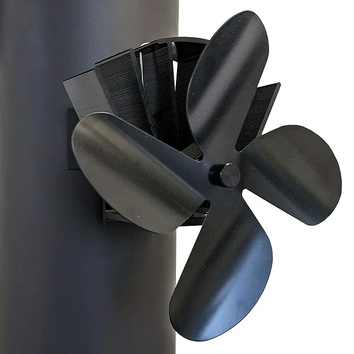 Firefix Ofenventilator - Stromlos - Nahaufnahme eines Ofenventilators aus schwarzem Metall, der an einem schwarzen Ofenrohr befestigt ist, um die Wärme im Raum zu verteilen.