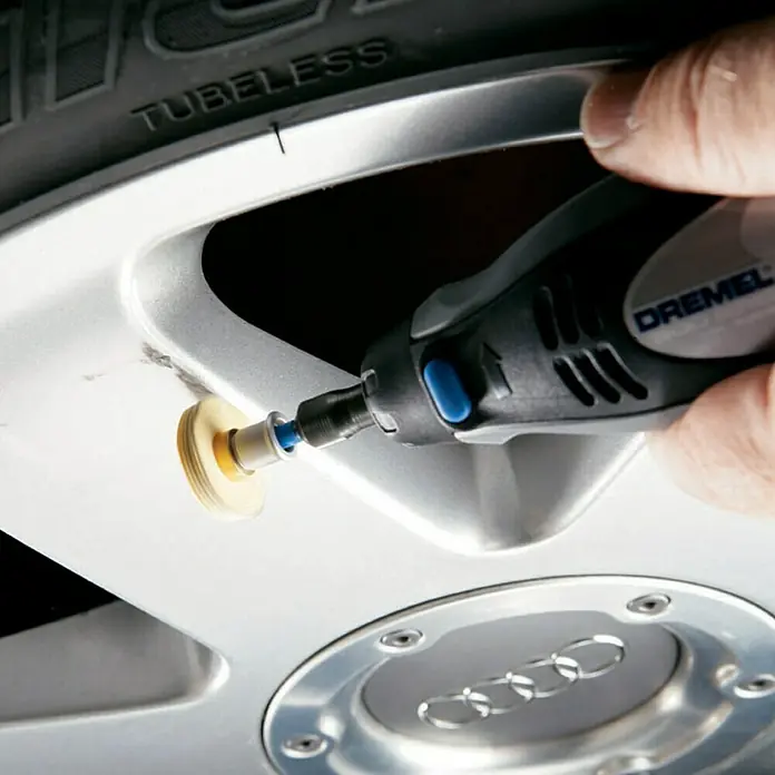 Dremel EZ SpeedClic Textilpolierscheibe 423 S - Arbeitsdurchmesser: 25 mm - Detailaufnahme eines Dremel-Werkzeugs, das zur Reparatur oder Reinigung einer Audi-Felge verwendet wird.
