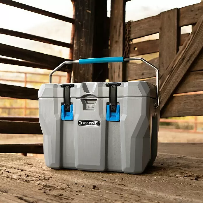 Lifetime Kühlbox Cooler - 26,5 l, Grau/Blau - Ein grauer 'LIFETIME' Kühler mit blauem Griff und Verschlüssen steht auf rustikalen Holzplanken im Freien.