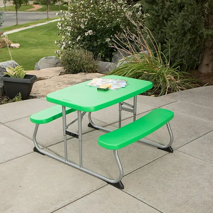 Lifetime Kinder-Picknicktisch - L x B x H: 83 x 90 x 54 cm, Polypropylen, Grün - Ein grüner Kindertisch mit Bänken steht auf einer Terrasse, umgeben von Grün. Ideal für Spiele und Picknicks im Freien.