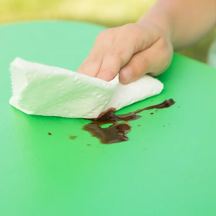 Lifetime Kinder-Picknicktisch - L x B x H: 83 x 90 x 54 cm, Polypropylen, Grün - Ein grüner Tisch wird mit einem Papiertuch von einer dunklen Flüssigkeit gereinigt. Der Tisch ist sauber und einsatzbereit.