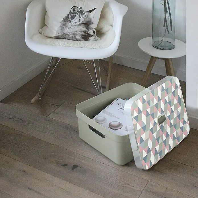 Sunware Aufbewahrungsbox Sigma Home - L x B x H: 44,5 x 34,5 x 18,3 cm, Kunststoff, Hellgrün - Ein dekorativer, hellgrüner Aufbewahrungskorb mit buntem Deckel steht auf einem Holzboden neben einem weißen Stuhl.