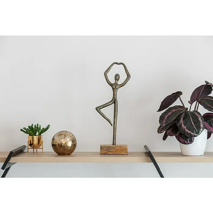 Dekoelement KugelDurchmesser: 10 cm, Glas, Braun - Dekorative Skulptur einer Tänzerin aus Metall auf einem Holzsockel, ausgestellt auf einem Regal mit Zimmerpflanzen und einer goldenen Kugel.
