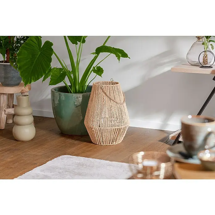 Laterne - Ø x H: 27 x 30 cm, Natur - Eine elegante, beigefarbene Laterne mit Seilgriff steht neben einer Topfpflanze, die eine warme, natürliche Atmosphäre im Raum schafft.