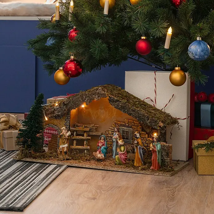 LED-Krippe Natur - L x B x H: 25 x 58 x 23 cm, Natur - Nahaufnahme einer Weihnachtskrippe unter einem festlich geschmückten Weihnachtsbaum mit Kugeln und Lichtern, die weihnachtliche Atmosphäre verbreiten.