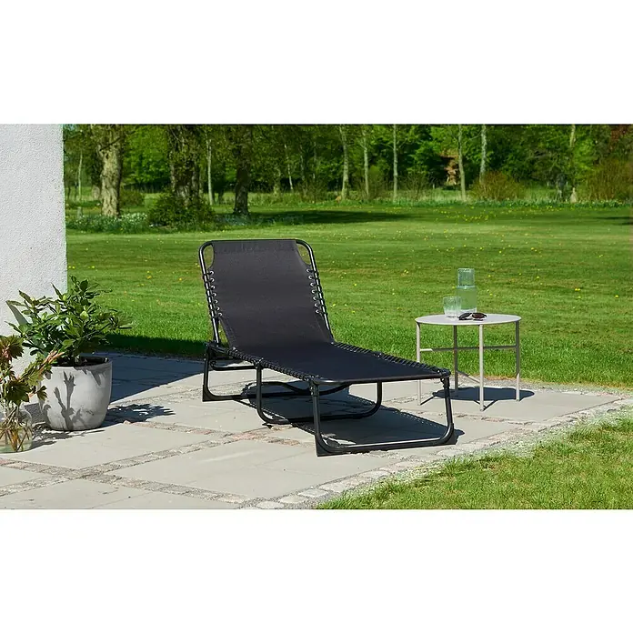 Gartenliege - B x T: 61 x 190 cm, Schwarz, Textil, Rückenlehne verstellbar - Eine stilvolle schwarze Sonnenliege steht auf einer Terrasse, neben einem Beistelltisch mit Getränken und einer Pflanze.