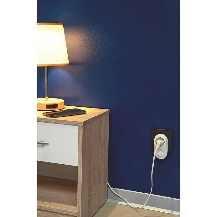 Voltomat Zwischenstecker - Dimmer, Max. Anschlussleistung: 280 W - Ein Nachtisch mit einer Lampe, einem Handy und einem intelligenten Stecker an der Wand. Intelligenter Stecker für smarte Steuerung.