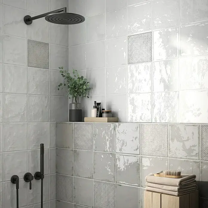 BHS Showroom Revestimiento de pared Rain Decor - 22,3 x 22,3 cm, Grigio, Brillante - Primer plano de una ducha moderna con azulejos cuadrados grises y blancos, complementada con elegantes accesorios y accesorios.