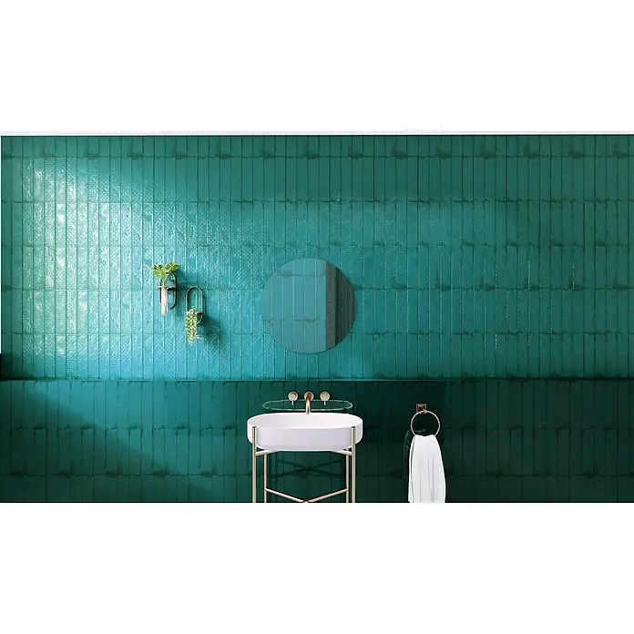 BHS Showroom Revestimiento de pared Rain Decor - 7,5 x 30 cm, Aquamarine, Brillante - Un baño con azulejos verticales de color turquesa en la pared y un lavabo blanco sobre un marco dorado, creando un ambiente moderno y elegante.