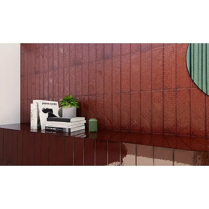 BHS Showroom Revestimiento de pared Rain - 7,5 x 30 cm, Bordeaux, Brillante - Primer plano de las baldosas de pared y base de color rojo óxido con un acabado brillante, mostrando un elemento de diseño elegante y moderno.