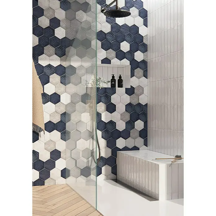 BHS Showroom Revestimiento de pared Rain - 19,8 x 22,8 cm, Hexagonal, Grigio, Brillante - Baño con azulejos hexagonales en varios colores y un banco de ducha.