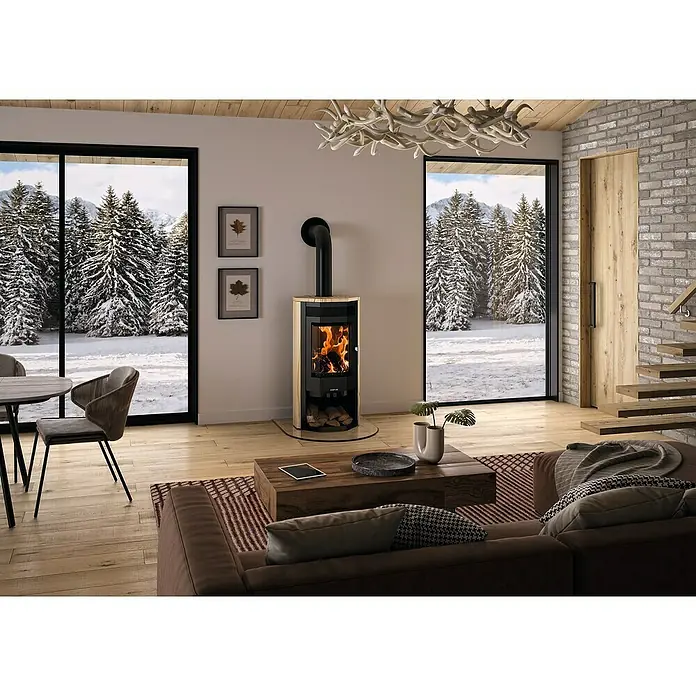 Justus Kaminofen Usedom 5 II - 5,5 kW, Raumheizvermögen: 88 m³, Material Verkleidung: Sandstein, Sandstein/Schwarz - Gemütliches Wohnzimmer mit einem Kaminofen, der Wärme und Atmosphäre verbreitet. Das Feuer knistert im Kamin.