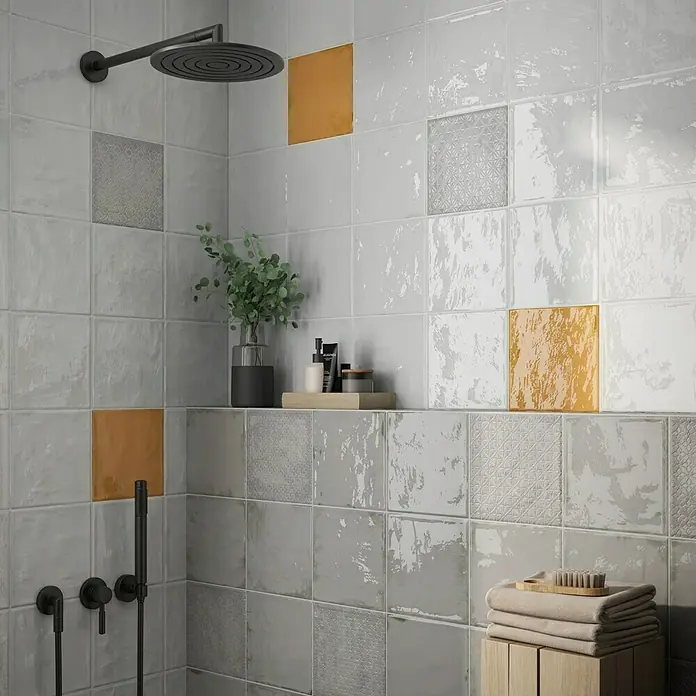BHS Showroom Revestimiento de pared Rain - 22,3 x 22,3 cm, Cuadrado, Kaki, Brillante - La imagen muestra azulejos de pared cuadrados modernos en gris y beige con un acabado brillante en una ducha. Los azulejos dan a la habitación un aspecto elegante.