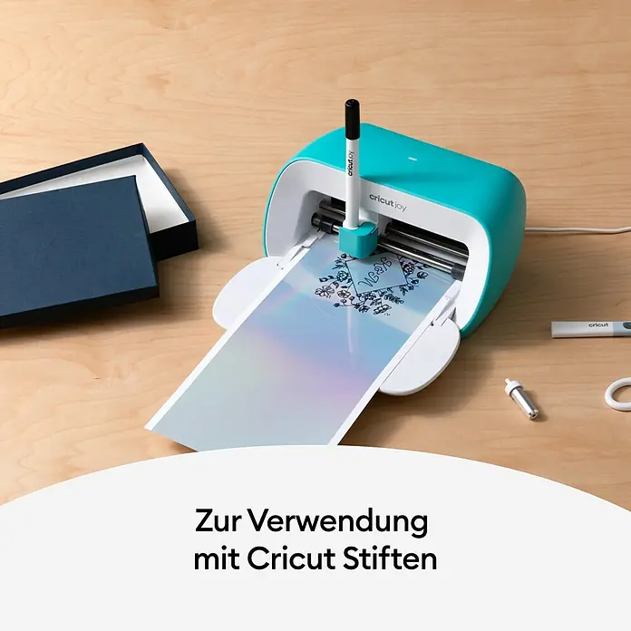 Cricut Joy Vinylfolie Smart Label Writeable - 4 Stk., Silber, 14 x 33 cm - Cricut Joy Schneidemaschine in Aktion beim Zeichnen eines Designs auf eine Karte, begleitet von einem leeren Karton.