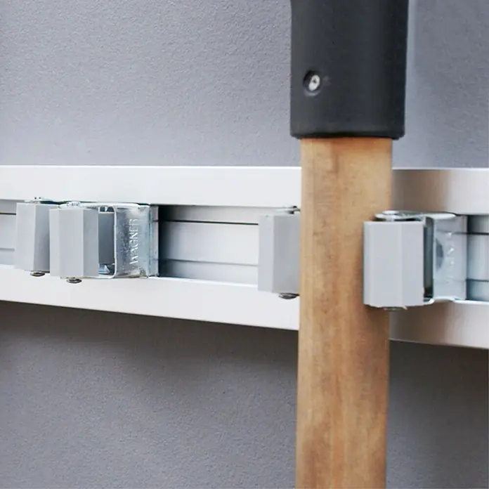 Wagner System Gerätehalter-Set Knopf EH 2048 - 2 Stk. - Nahaufnahme einer Wandhalterung mit Werkzeugaufnahme. Die Halterung ist weiß und an einer grauen Wand montiert. Ideal für Garage oder Werkstatt.