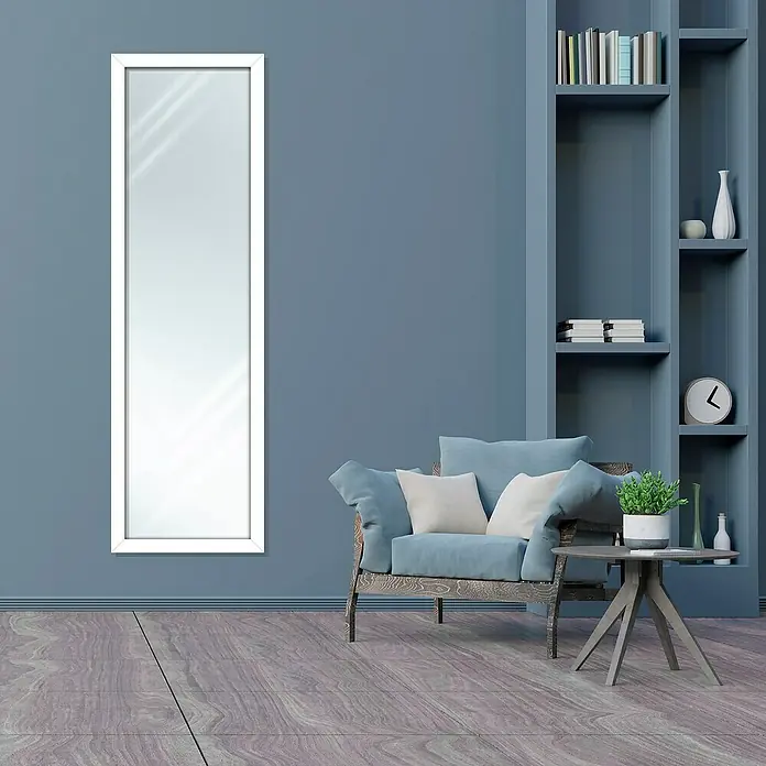 Espejo de pared Lincoln - 45 x 147 cm, Blanco - Un espejo largo con marco blanco en una pared azul, junto a un sillón y una mesa auxiliar con decoraciones, creando un ambiente elegante.
