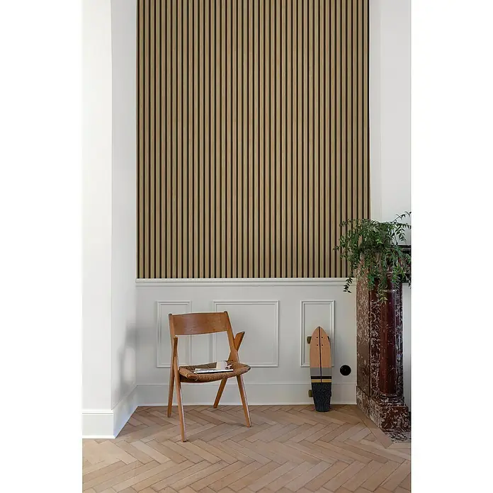 Papel pintado Listones de madera - Marrón, 10 x 0,53 m - La imagen presenta una pared con listones de madera que ofrecen una estética elegante y moderna. Una silla de madera y un monopatín complementan la decoración.