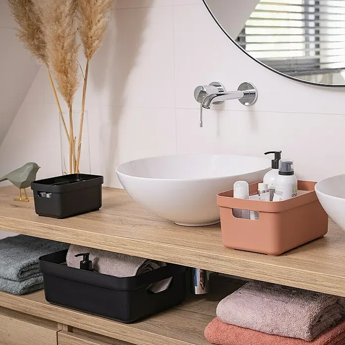 Sunware Aufbewahrungsbox Sigma Home - L x B x H: 35 x 24,6 x 12,2 cm, Kunststoff, Schwarz - Badezimmerablagen: Eine Nahaufnahme von einer Kollektion von schwarzen und terrakottafarbenen Ablagen, die auf einem Holzbadezimmertisch ausgestellt sind.