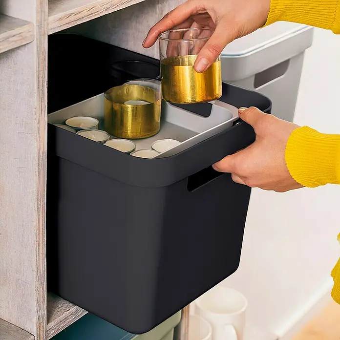 Sunware Aufbewahrungsbox Sigma Home - L x B x H: 35 x 24,6 x 24,3 cm, Kunststoff, Schwarz - Ein dunkler Aufbewahrungskorb mit goldenen Kerzen und Teelichtern wird in ein Regal gestellt. Praktische und stilvolle Aufbewahrungslösung.
