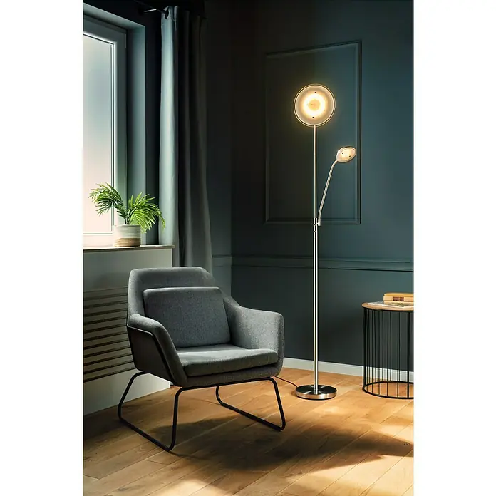 Tween Light LED-Deckenfluter Alaska - Höhe: 1,8 m - Stimmungsvolle Leseecke mit einem modernen Stehleuchte mit zwei Leuchten, einem grauen Sessel und einem kleinen Beistelltisch.
