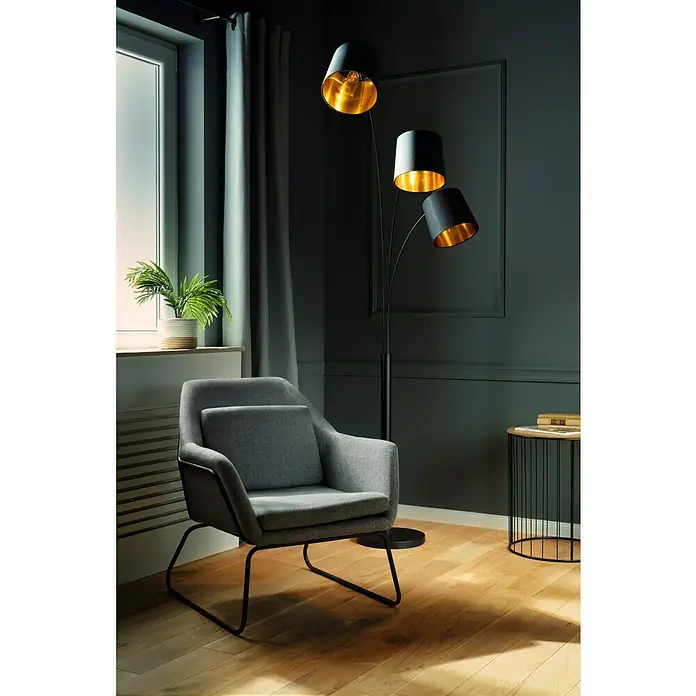 Tween Light Stehleuchte Cremona - 120 W, Höhe: 210 cm, Mattschwarz, Mattschwarz, Gold, E14 - Ein grauer Sessel und eine Stehlampe mit drei Lampenschirmen. Die Stehlampe hat goldene Innenseiten und ist ein Blickfang.