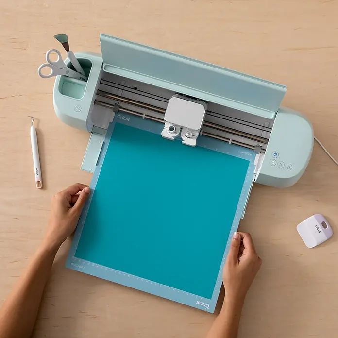 Cricut Vinylfolie Color Change Hot Permanent - 1 Stk., Türkis/Hellblau, 30 x 60 cm - Cricut Schneideplotter mit einer türkisfarbenen Schneidematte, die eingelegt wird, ideal für kreative Bastelprojekte.